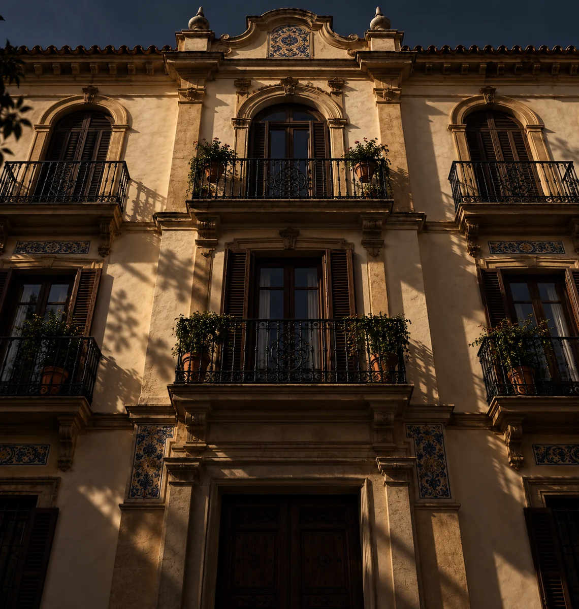 Spanische Stadthausfassade im Abendlicht, mit schmiedeeisernen Balkonen, Fensterläden aus Holz und blau-weißen Azulejos